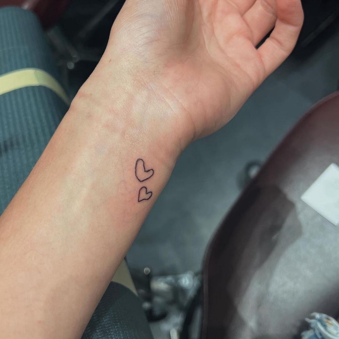 Tiny tattoo of the letter 
